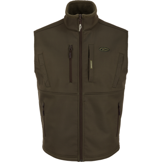 The MST Hole Shot Two-Tone Eqwader Vest by Waterfowl in Green Timber is sleeveless and windproof with a high collar, four zippered pockets, and a subtle chest logo. Thick material makes it perfect for outdoor wear. Laid flat on white.