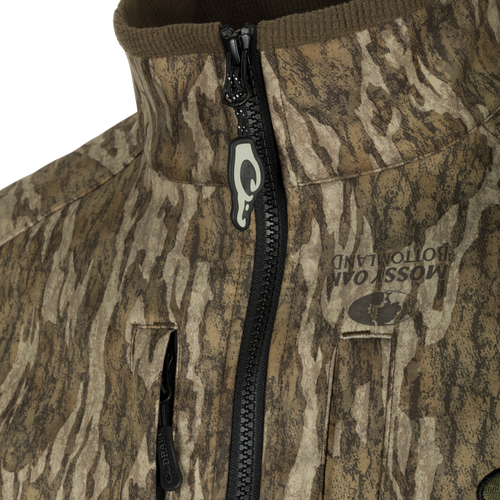 Close-up of the MST Windproof Softshell Jacket featuring camo pattern, high collar, zippered chest pockets, and branded zipper pull, designed for optimal warmth and breathability.