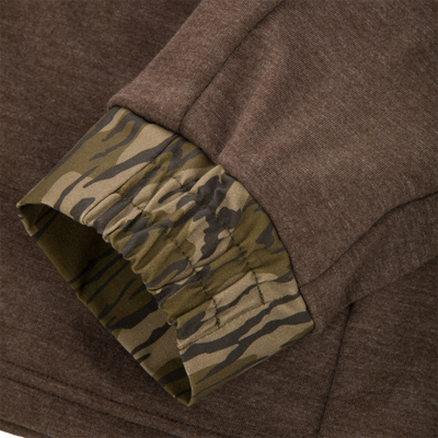 Close-up of MST Heritage Hybrid Windproof Jacket showing brown jersey outer layer and olive-tan camouflage elastic inner lining, highlighting its durable, weather-resistant design.