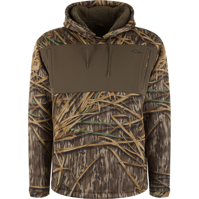 Slacker Wader Pocket Hoodie in Mossy Oak Original Shadow Grass camouflage with a solid olive green wader pocket and a fleece-lined hood.