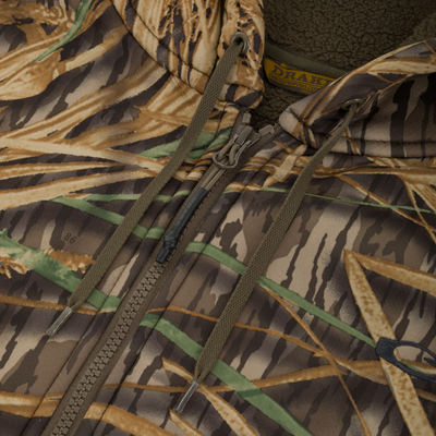 Close-up of the Slacker Quarter Zip Hoodie by Waterfowl, featuring a camouflage polyester fleece exterior, quarter zipper, hood with drawstrings, fleece lining, and a partial brand label inside the collar.