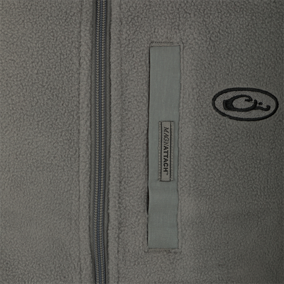 A close-up of the Youth Camp Fleece Vest's zipper and logo, showcasing its durable 100% Polyester and 210 gram Micro Fleece material.