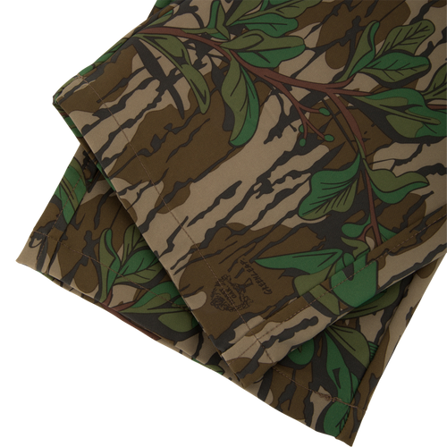Ol' Tom Tech Stretch Turkey Pants with camouflage pattern, showcasing folded fabric designed for flexibility and comfort, featuring cargo pockets and breathable mesh areas.