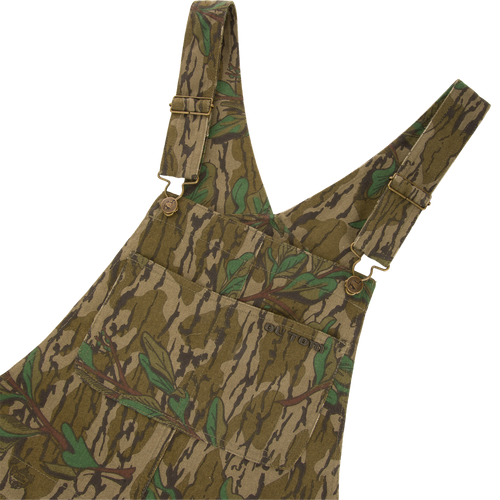 Throwback 80 Field Bib featuring camouflage design, metal button details, triple needle stitching, and reinforced knees, ideal for durable use in demanding hunting environments.