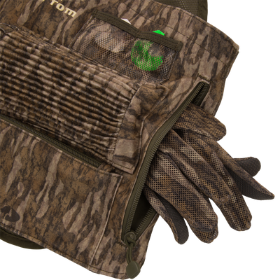 Time & Motion™ Gunslinger Turkey Vest with visible gloves, designed for intuitive gear access, featuring multiple call pockets and a removable seat cushion for hunting convenience.