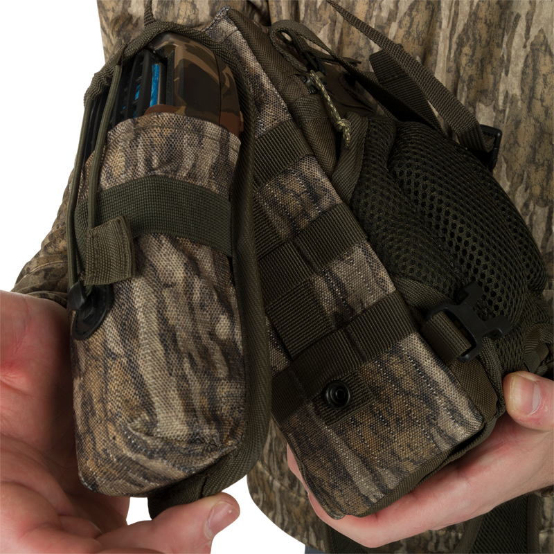 Turkey Chest Pack held by a person, featuring a lightweight design with multiple pockets, loops, a detachable bino harness, and a stowable rain fly.