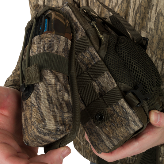 Turkey Chest Pack held by a person, featuring a lightweight design with multiple pockets, loops, a detachable bino harness, and a stowable rain fly.