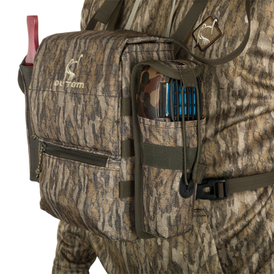 Turkey Chest Pack with camouflage design, featuring a removable bino harness, multiple pockets, and a stowable rain fly, ideal for hunting trips.