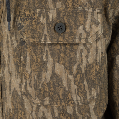 Close-up of a brown camouflage Spoonie Campfire Hoodie featuring a single button-flap chest pocket with the text MOSS BOTTOM printed above it.