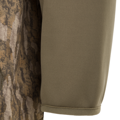 Close-up of the olive green and camouflage Spoonie Hollywood Jacket sleeve, featuring wind-resistant fabric in both solid olive and a brown-and-tan pattern.