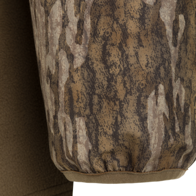 Close-up of a Spoonie Eqwader Quarter Zip sleeve featuring a brown and tan tree bark camouflage pattern with an elasticized cuff.