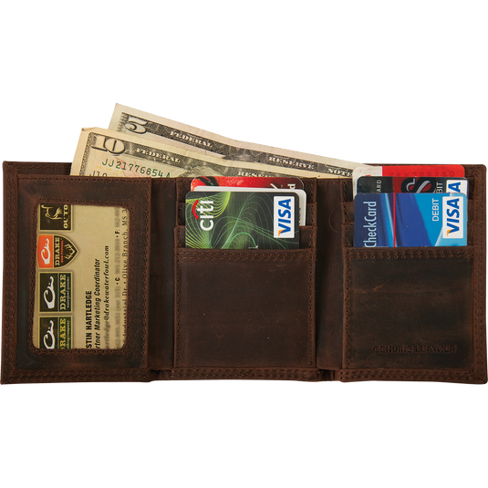 A brown leather tri-fold wallet with the Drake Logo metal oval on the outside, filled with money and credit cards.