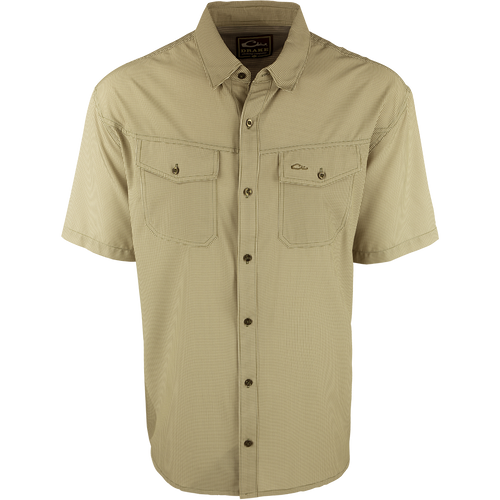 A close-up of the Traveler's Check Shirt S/S, a lightweight and breathable poly/spandex shirt with four-way stretch for freedom of movement. Ideal for the man on the go, it features moisture-wicking technology and 2 chest pockets with button flaps. Perfect for exotic vacations or running around town.