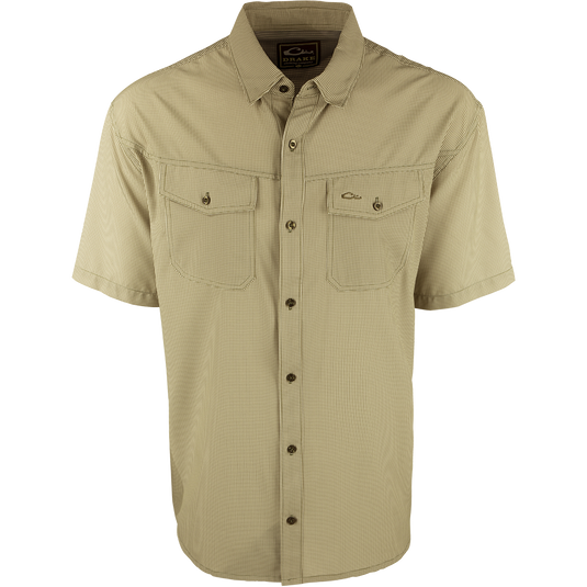 A close-up of the Traveler's Check Shirt S/S, a lightweight and breathable poly/spandex shirt with four-way stretch for freedom of movement. Ideal for the man on the go, it features moisture-wicking technology and 2 chest pockets with button flaps. Perfect for exotic vacations or running around town.