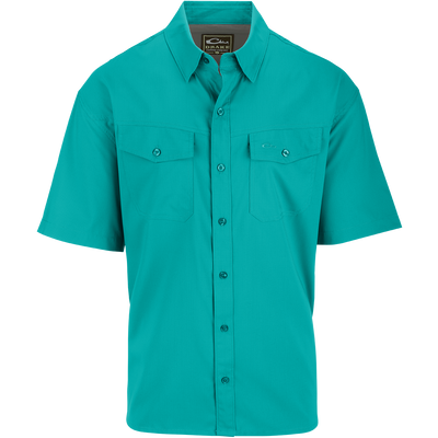 A close-up of the Traveler's Solid Dobby Shirt S/S, featuring a hidden button-down collar, two chest pockets with button-through flaps, and a split tail hem. Constructed with 100% Polyester textured dobby fabric, this shirt is featherweight at 79 GSM, moisture-wicking, and quick-drying. It also offers UPF30 sun protection. Versatile for any occasion, this shirt is perfect for seasons to come.