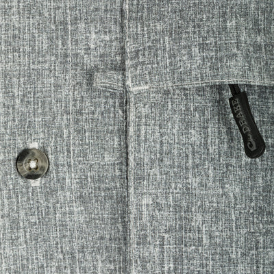 Heritage Heather Shirt L/S: A close-up of a button on a grey patterned shirt made of lightweight, moisture-wicking polyester fabric with UPF30 sun protection.