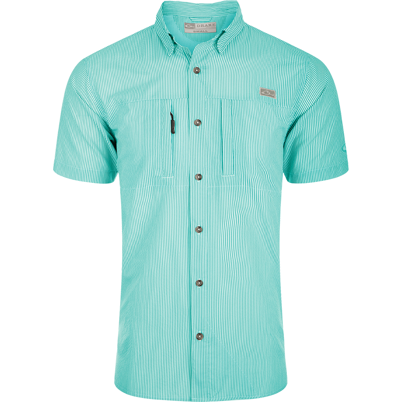 Classic Seersucker Stripe Shirt S/S: A close-up of a soft, featherweight shirt with a seersucker texture. Features include UPF 30 sun protection, moisture-wicking, and a button-down collar. It has a hidden zippered right chest pocket and a left chest pocket with a Magnattach™ closure. The vented cape back provides additional ventilation, and the split tail hem allows for versatile styling. The image shows the shirt's pattern and fabric.