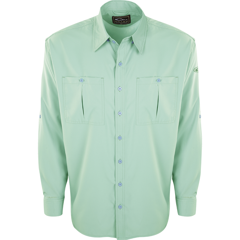 A close-up of the Flyweight Shirt with Vented Back L/S, featuring a green button-up design, collar, and sleeve. Made of ultra-lightweight polyester, it offers quick-drying, moisture-wicking, and breathable properties. With Sol-Shield™ UPF 50+ sun protection, vented mesh back, and horizontal chest pockets, it's perfect for warm-weather outdoor activities.