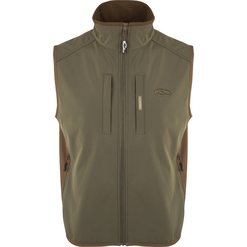 EST Windproof Tech Vest, featuring a logo and zipper details. This khaki vest is made of high-quality polyester tech shell and bonded fleece lining with a windproof membrane. It's perfect for outdoor activities and can be worn as a core or outer layer. Stay warm and stylish with this versatile vest from Drake Waterfowl.