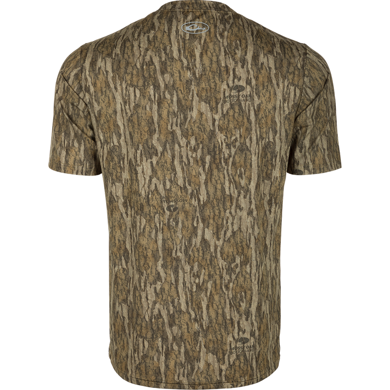 Youth EST Camo Performance Short Sleeve Crew, a back of a shirt with a logo close-up. Ideal for outdoor activities with 4-Way Stretch, Shield 4 Sun™ UPF 50+, Shield 4 Coolant™, Shield 4 Odor™, and Shield 4 Stains™ treatments.