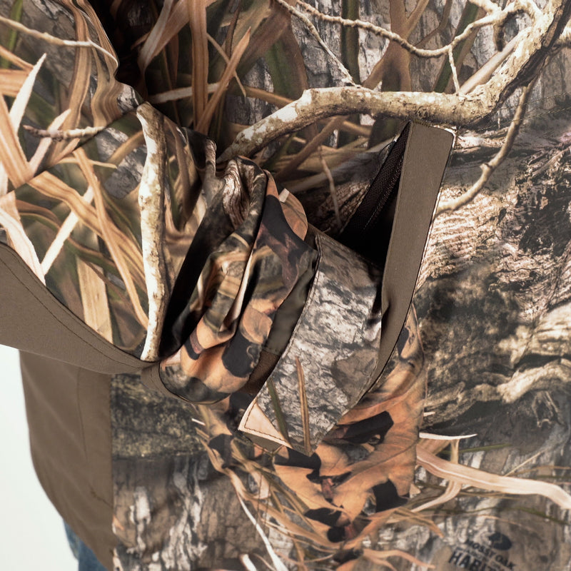 A person wearing the EST Heat-Escape Full Zip 2.0, a camouflage shirt, in an outdoor setting.